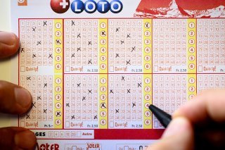 Une personne remplit un bulletin de Swiss Loto au siege de la Loterie Romande.